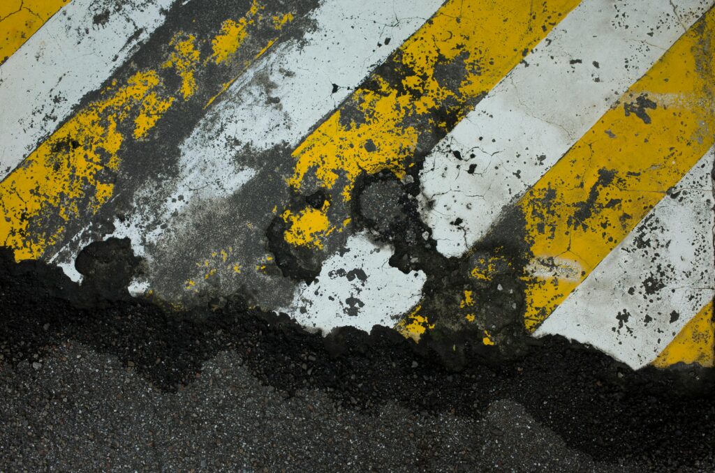 Old asphalt with yellow and white strips, reflecting our Asphalt Removal Colorado Springs Services