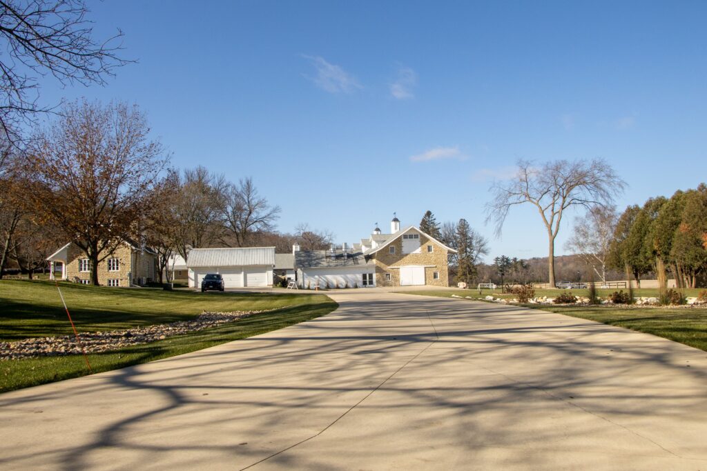 Charming rural estate with a long driveway in Rochester, MN, captured on a sunny day reflecting our concrete driveway replacement Colorado Springs services.